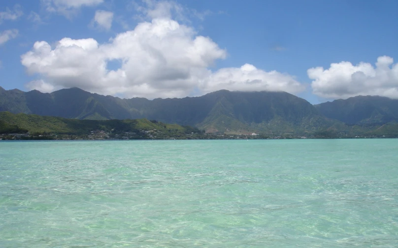 the blue water is below the mountain range