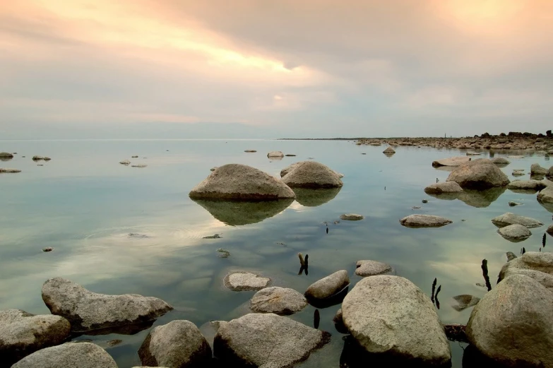 large rocks on the ocean at sunset and clouds