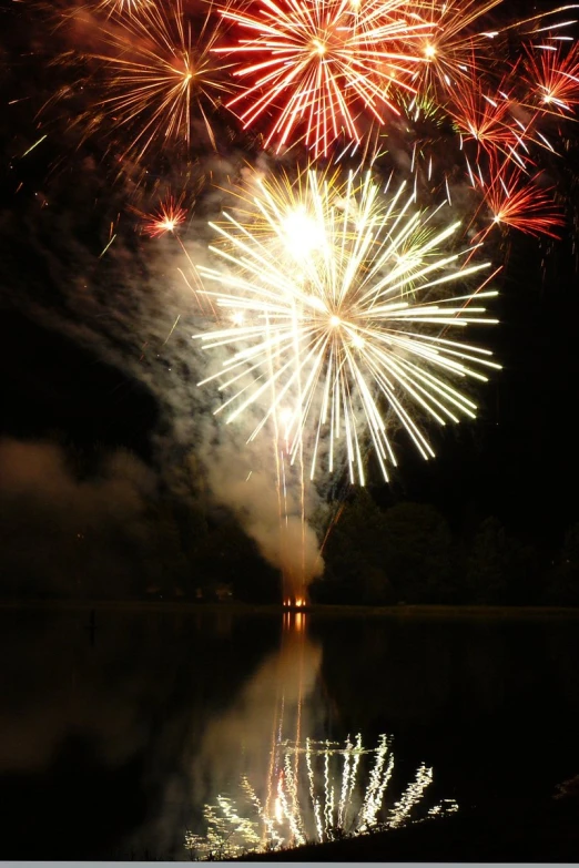 the fireworks are lit up over the water