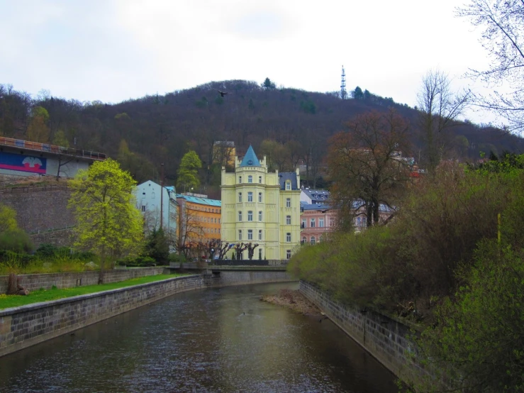 a river and buildings by a hill side