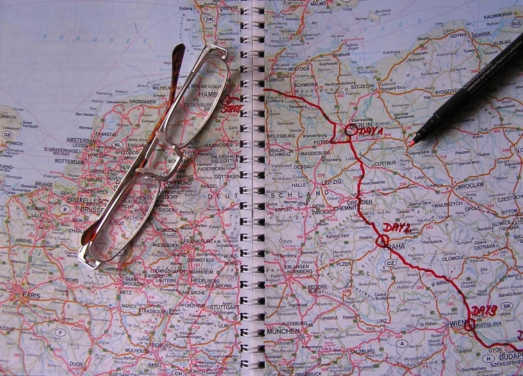 a map with glasses and a pen sitting on top