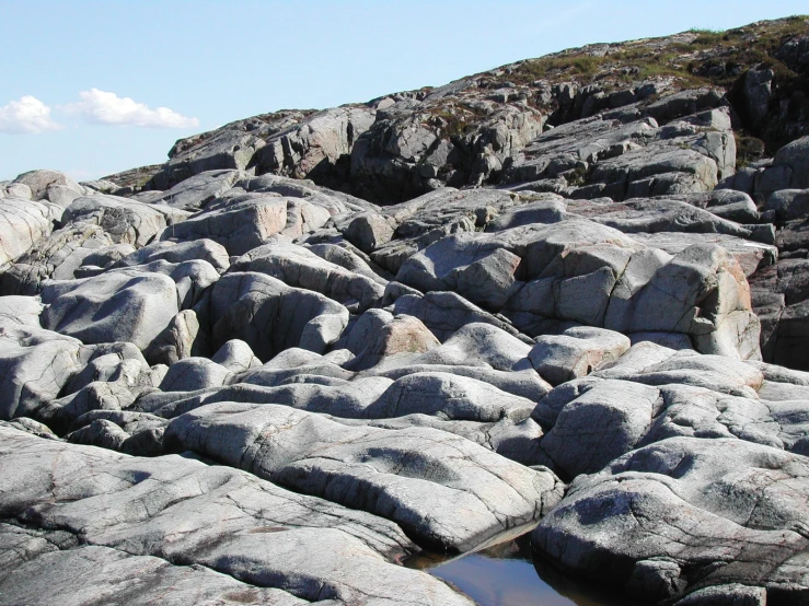 many large rocks are on a small area of grass