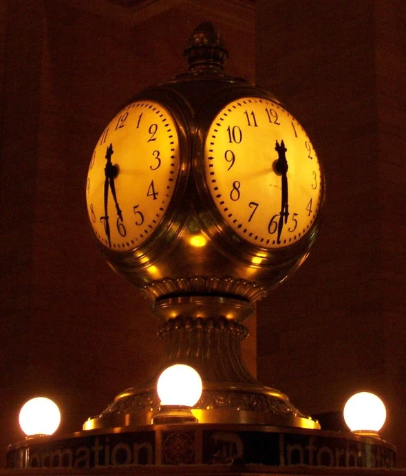 a large clock has three faces that are yellow