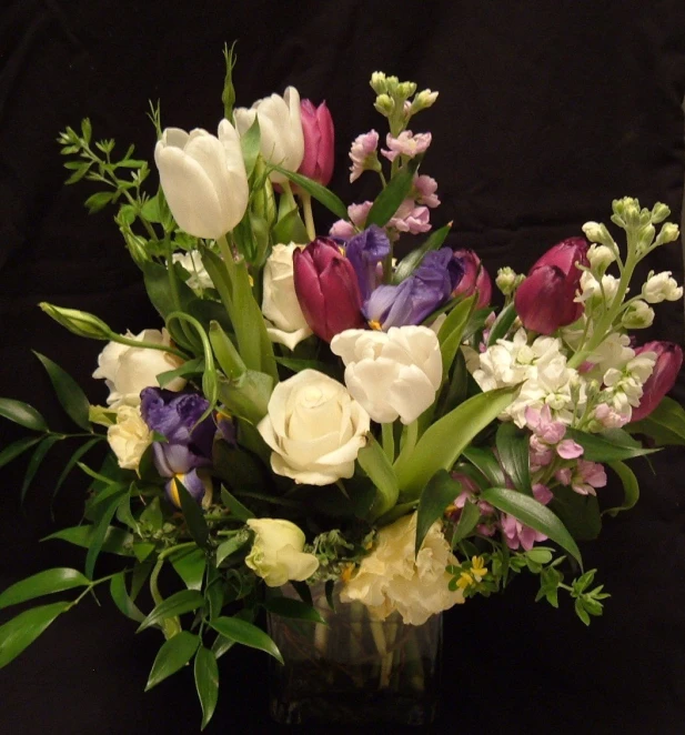 a bunch of flowers sit in a vase on a black background