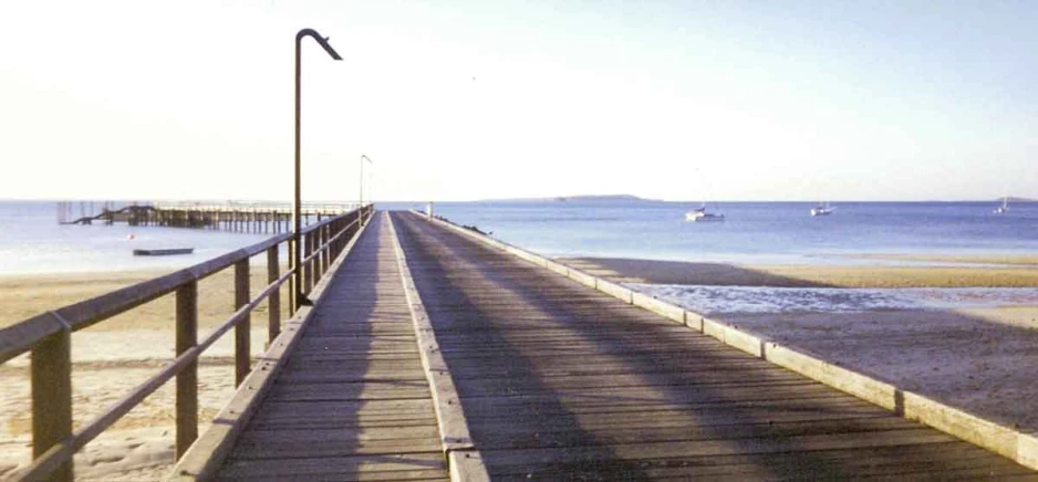 the boardwalk leads to a small dock on the beach