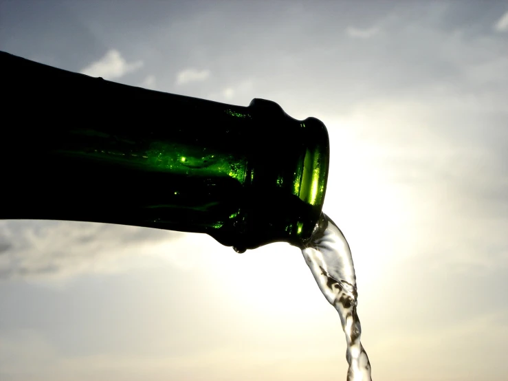 the silhouette of a person pouring water out of a bottle