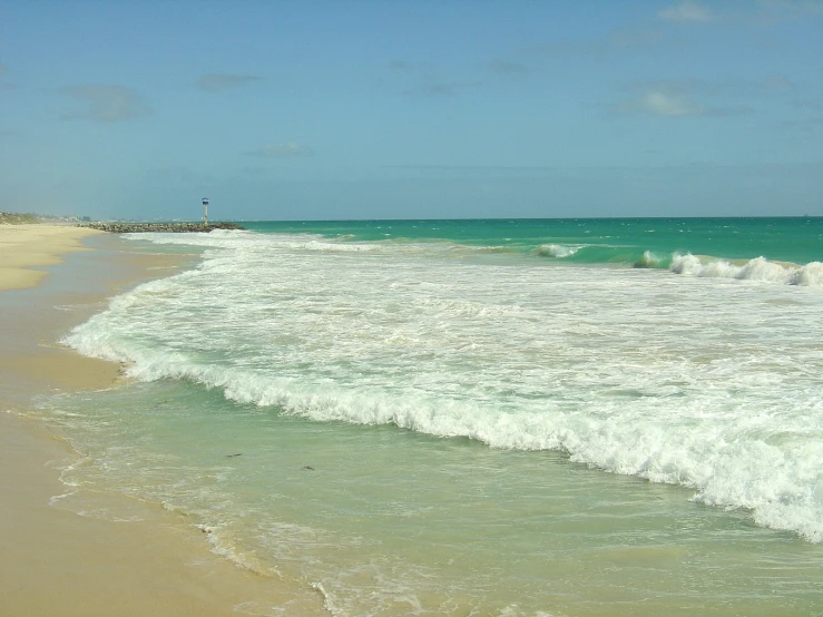 an ocean beach is shown with the water crashing on it