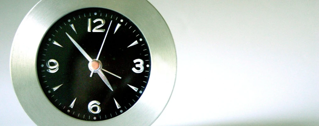 a black and silver clock showing seven o'clock