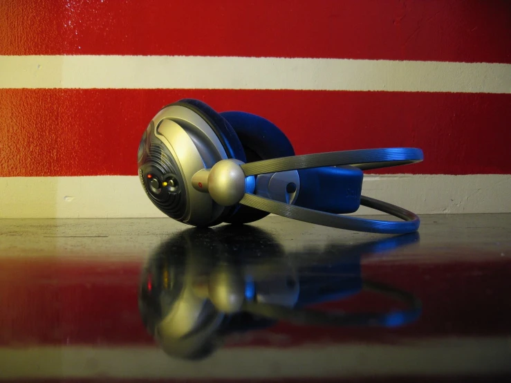 an image of headphones on a table with a striped wall