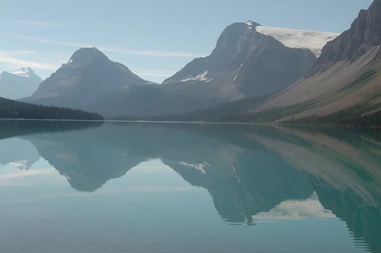 water is reflecting the snowy mountains in a lake