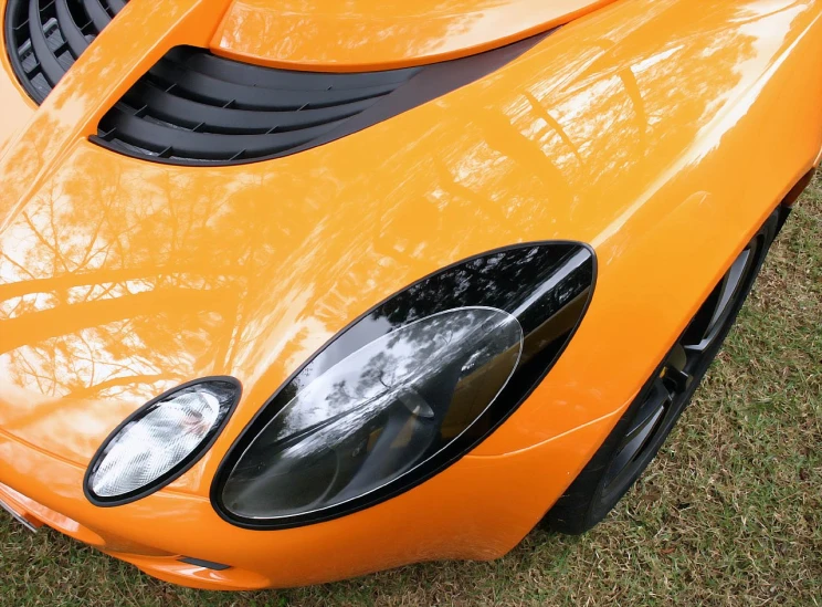 the front end of an orange sports car