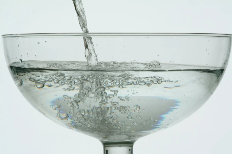 water is poured into an empty glass of water