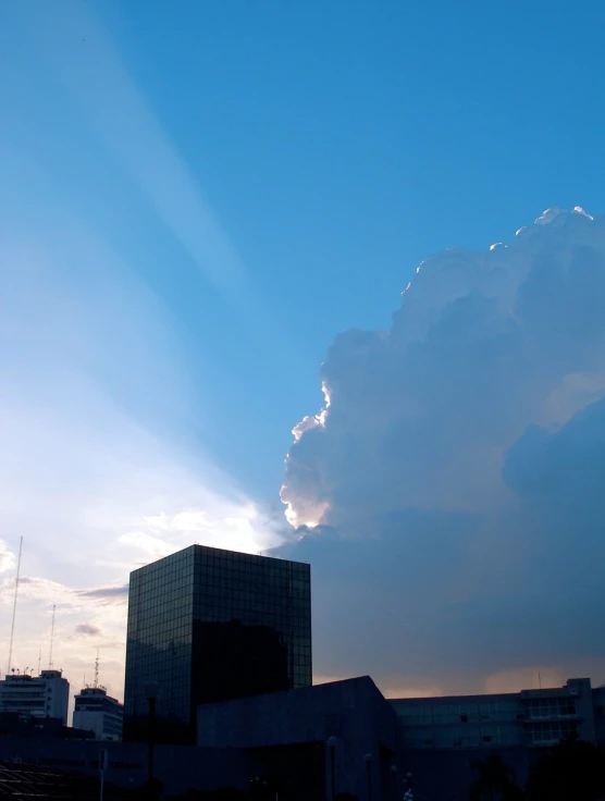 a large cloud looms over buildings in the sky