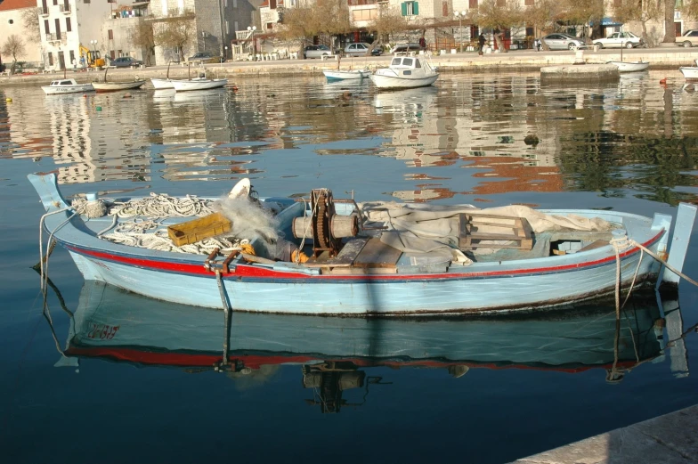 a small boat is on the water near some other boats