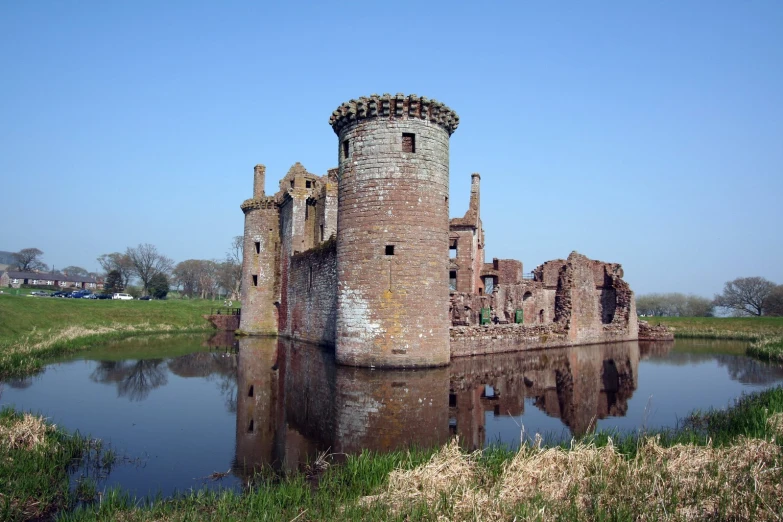 a castle and moat on the side of a lake