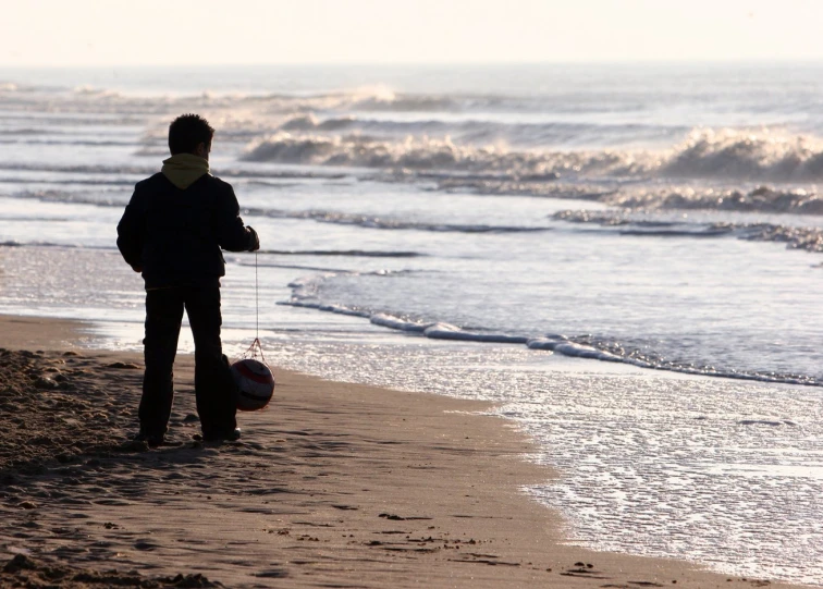 a man holding a bag on the beach