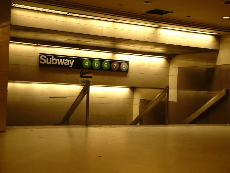 a subway sign in the middle of an empty lobby
