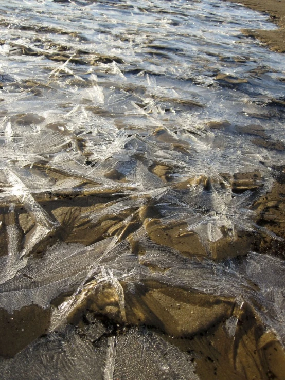 water flowing on sandy beach area next to shore