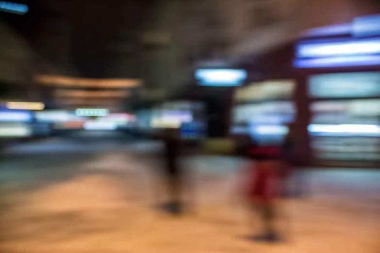 blurry pograph of two people walking down the sidewalk