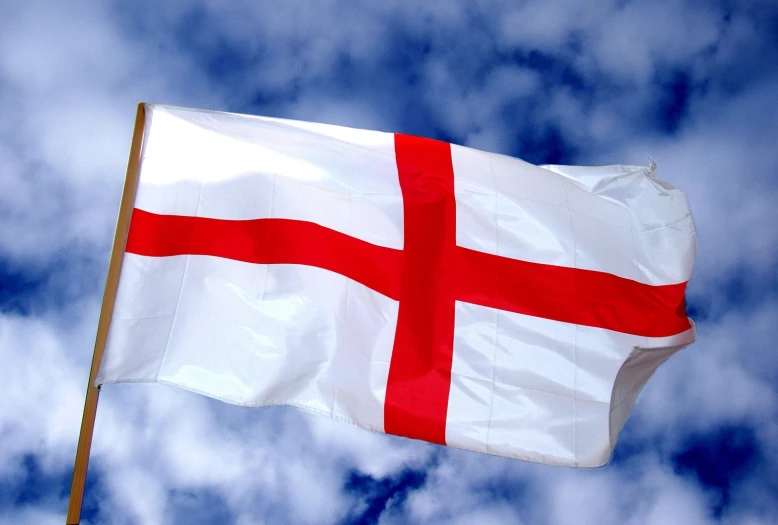 a close up of a danish flag with a blue sky behind it