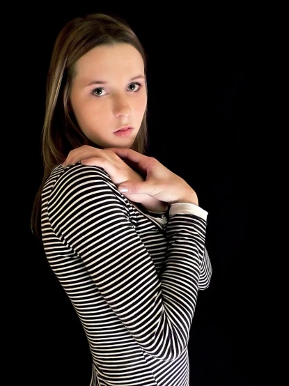 woman posing in striped dress on black background