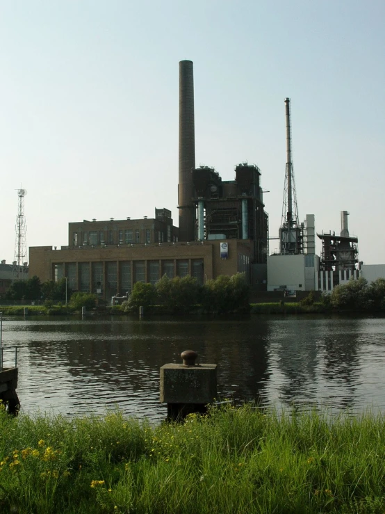 a factory sits behind a large river