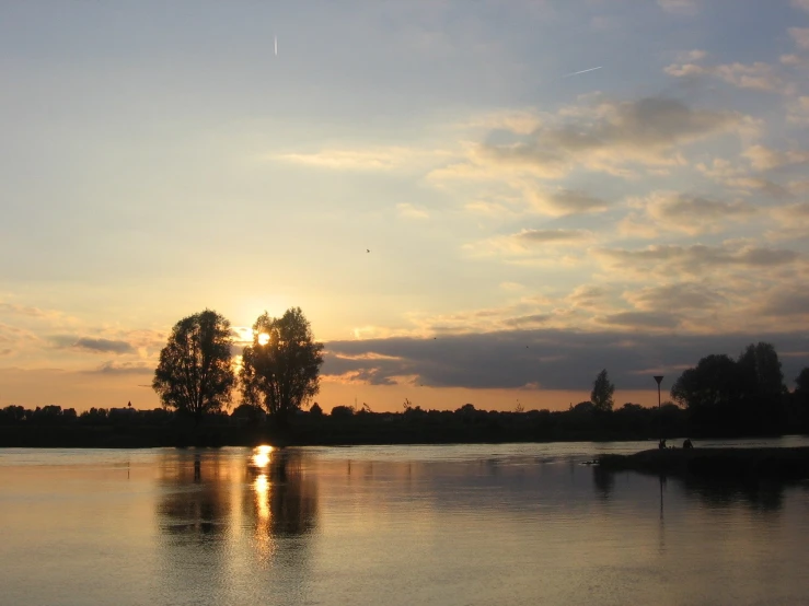 an evening view of trees by the water