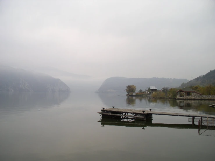 some water boats and trees on a foggy day