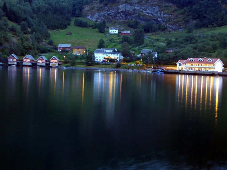 a small group of houses at the shore of a lake