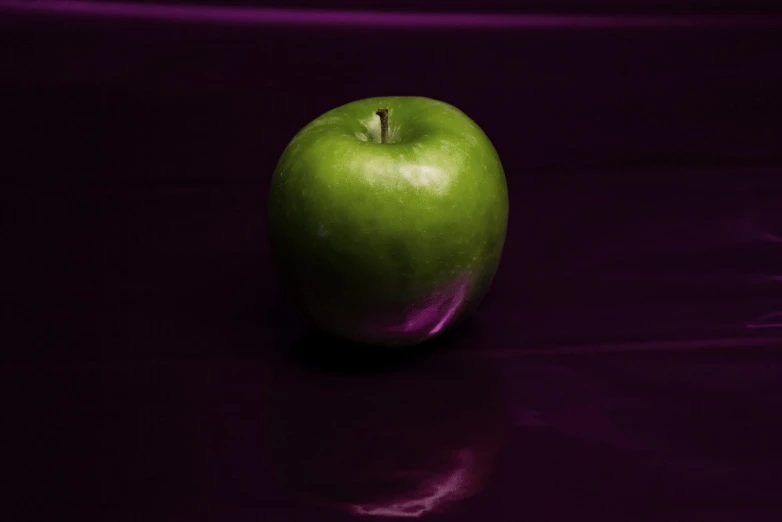 a green apple with purple liquid is shown