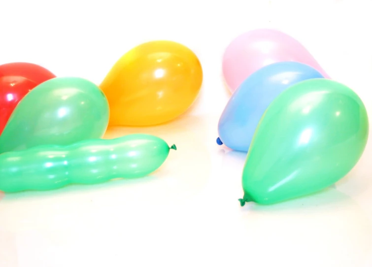 five colorful balloons with the top on a white surface