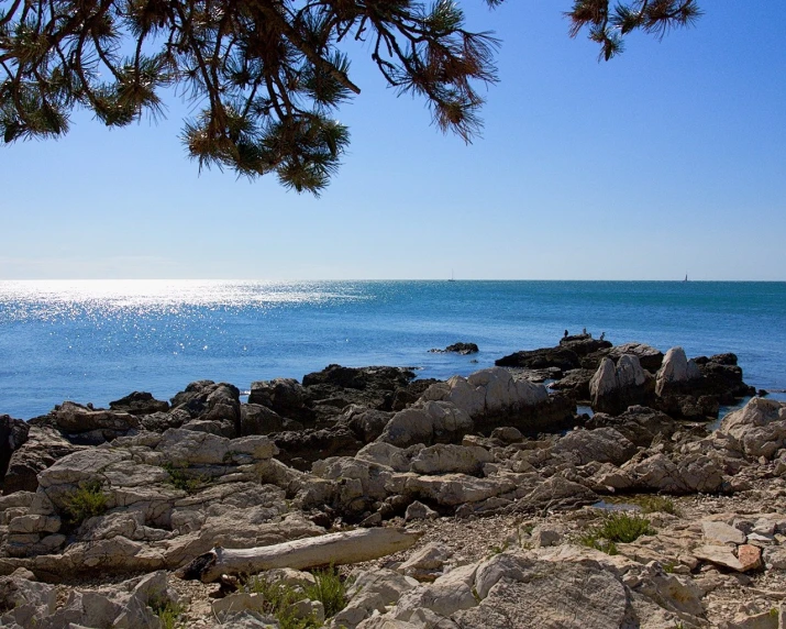 the ocean and sky near the rocks at the beach