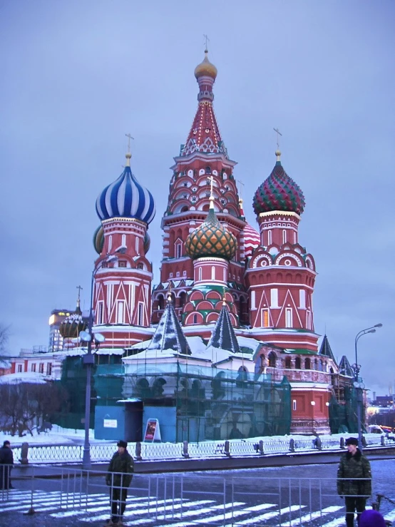 a red building with two towers and two people walking