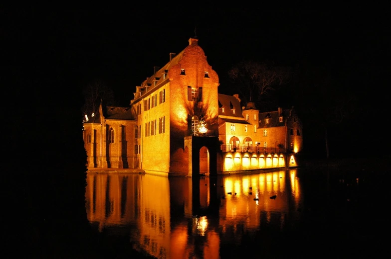 a large building at night is reflected in the water