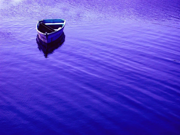 a rowboat sitting in the water on a calm day