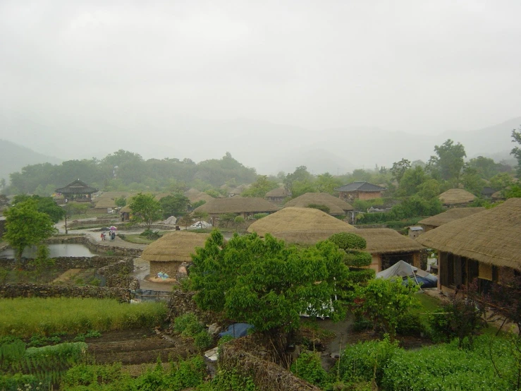 thatched huts and a river in a village in rural asia
