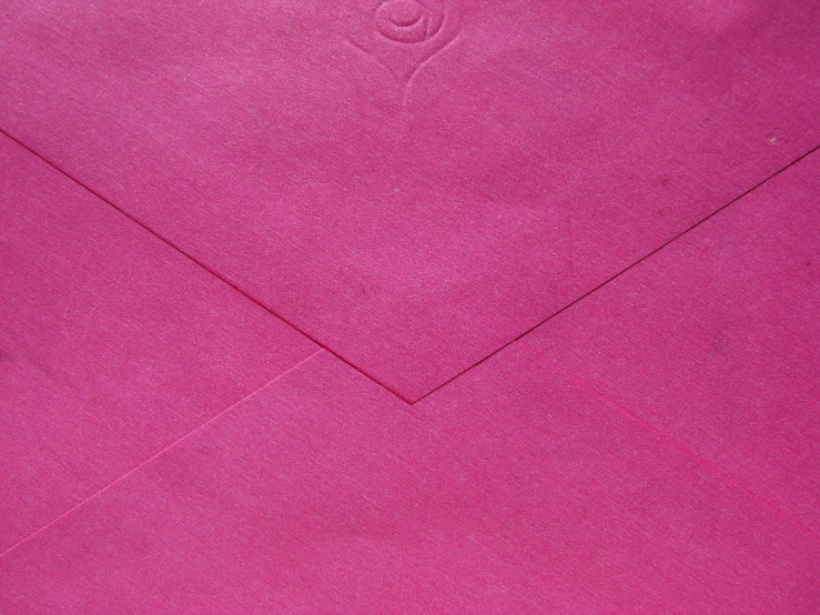 a close up of a bright pink envelope with the corner cut out