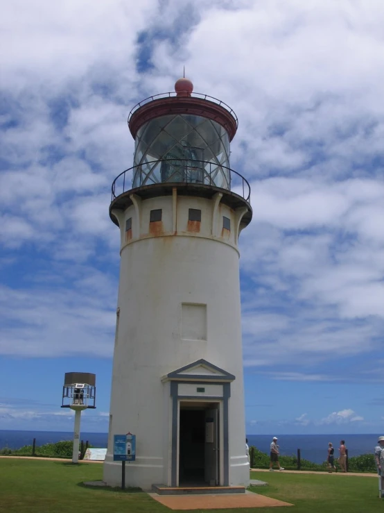 a small lighthouse next to some people