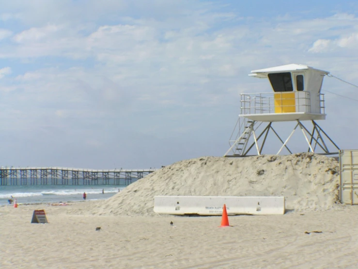 a lifeguard house on the beach next to some construction cones