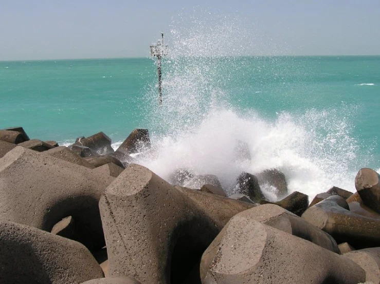 waves splash over large rocks on the beach