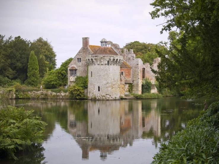 the large stone building is sitting next to water