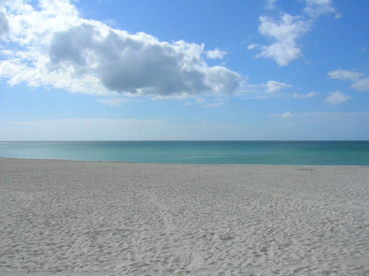 a beach area with a lot of footprints in the sand and the ocean