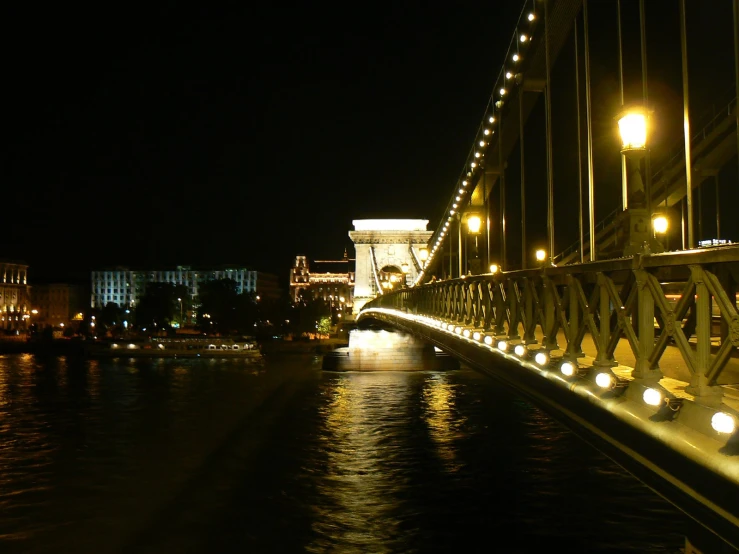 a bridge that has lights and buildings on the other side of it