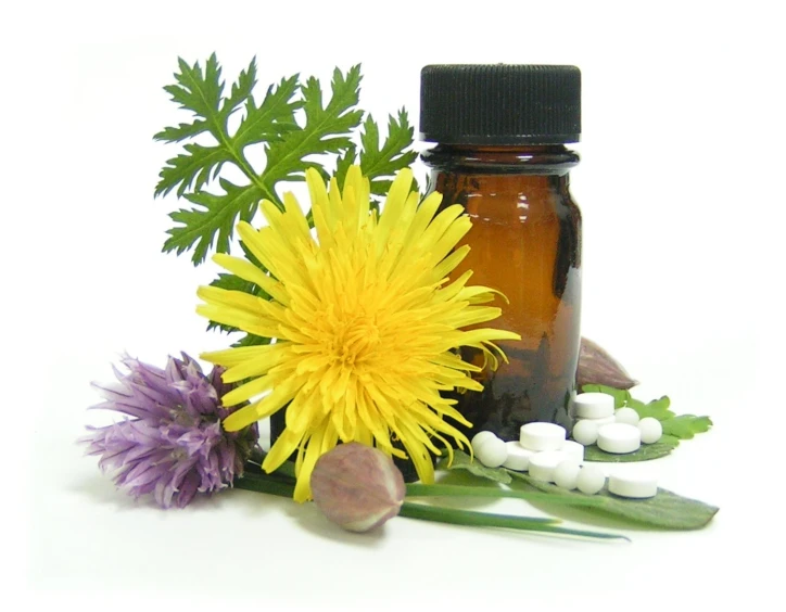 a bottle filled with essential oils next to a yellow flower