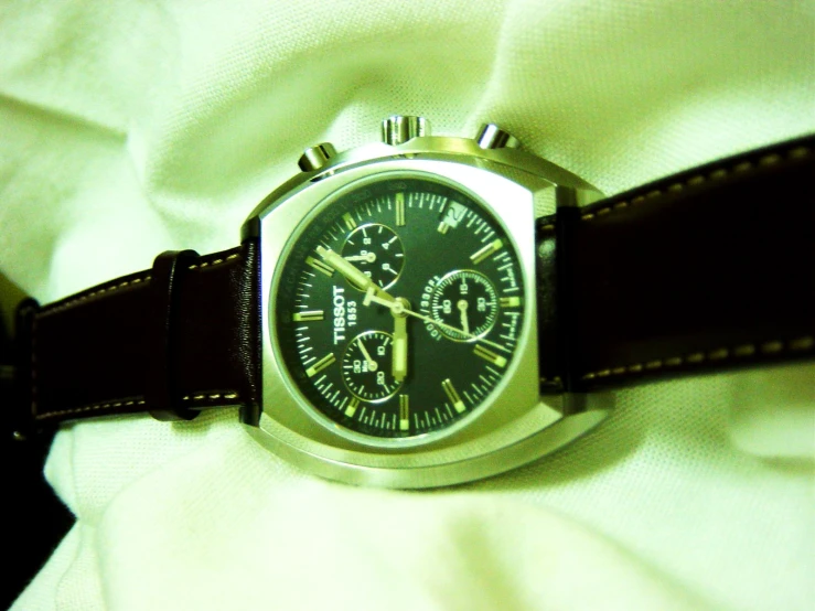 a watch is shown sitting on a piece of fabric