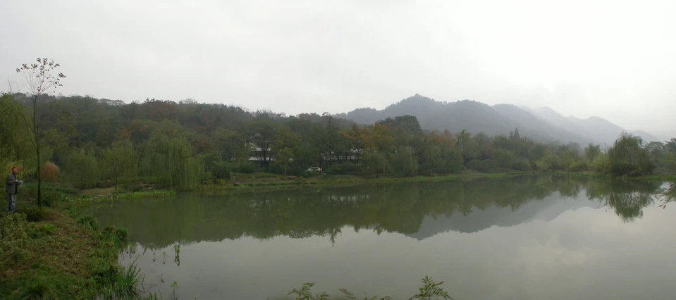 a lake surrounded by green trees in the middle of a forest