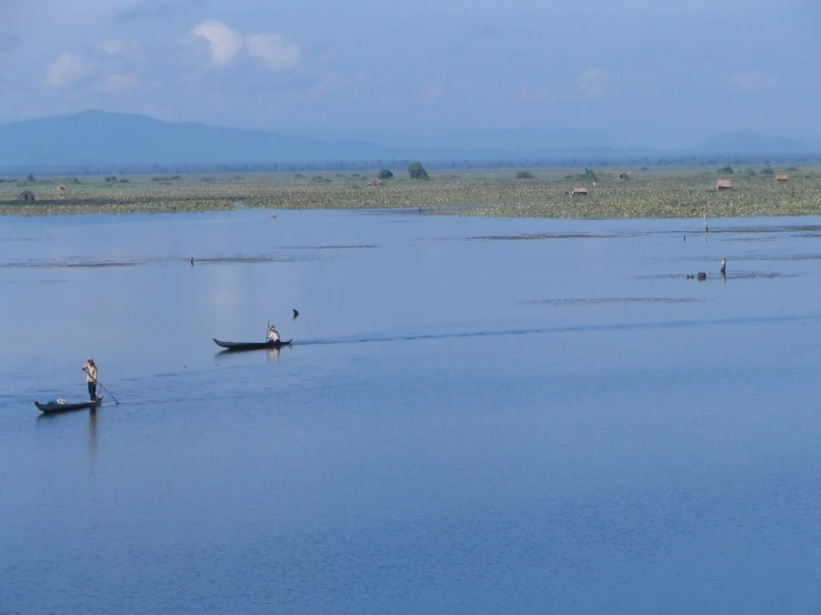 the person is in a small boat on a very large lake