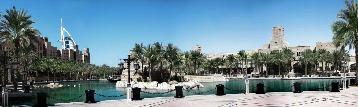 a beautiful city with palm trees in front of a body of water