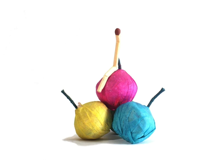 three colorful balls of yarn next to one another on a white background