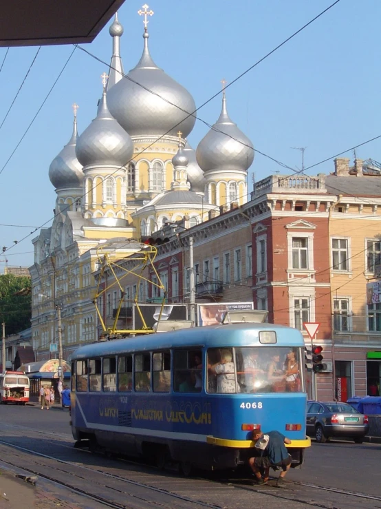 a small blue trolly car on the side of the road